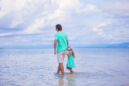 回观年轻的父亲与他的小女孩在海边散步，