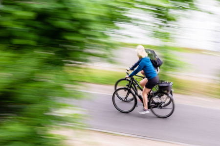 两个自行车骑手在一个循环路径与相机做运动模糊效果