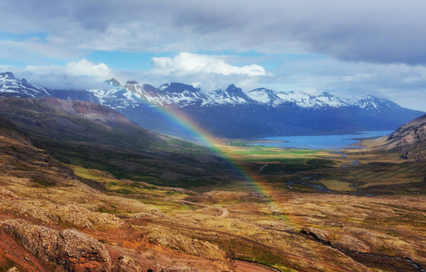 在冰岛, 山上的美景和一点小雨和彩虹。色彩鲜艳。戏剧性的积云。欧洲