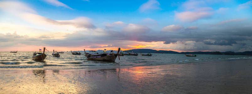 夏季日在泰国奥南海滩日落时传统长尾船全景