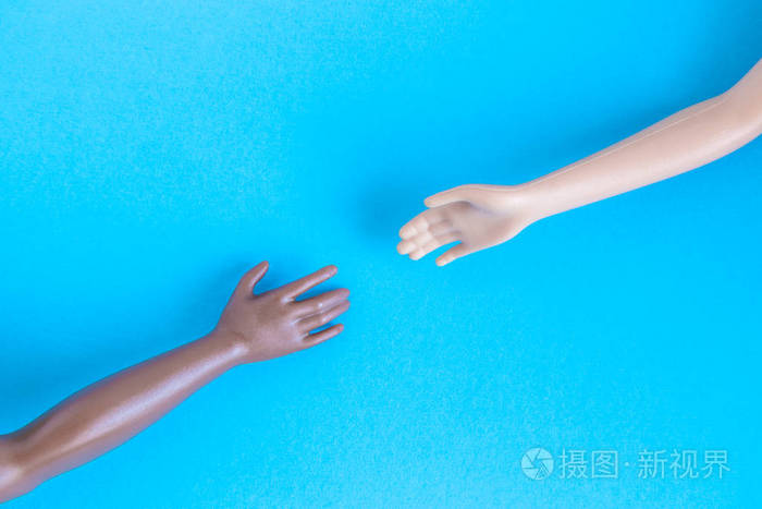 黑白相间的娃娃手伸向对方宽容与种族多样性合作最小创意概念
