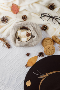 秋季和冬季作文。热咖啡与棉花糖, 围巾, 饼干, 帽子, 颠簸和秋天的叶子。平躺, 顶部视图