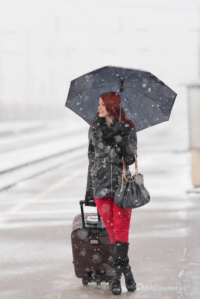 在车站等候火车的年轻女子