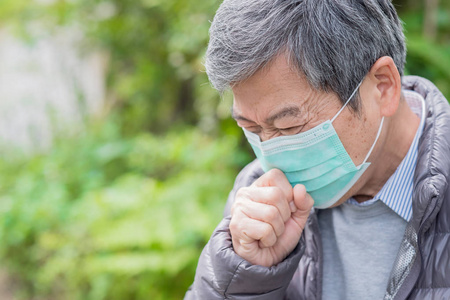 老头咳嗽老人感冒了, 戴着面具在户外照片