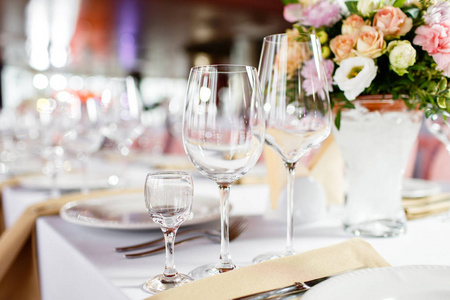 新婚夫妇的桌子。在豪华婚礼招待会上的餐桌设置。桌上美丽的花朵