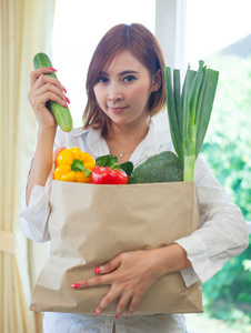 蔬菜在购物袋里的年轻女子