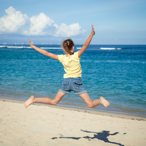 飞翔在蓝色的大海跳沙滩女孩岸在暑假中我