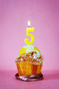 生日蛋糕以燃烧的蜡烛作为数字五在粉红色照片