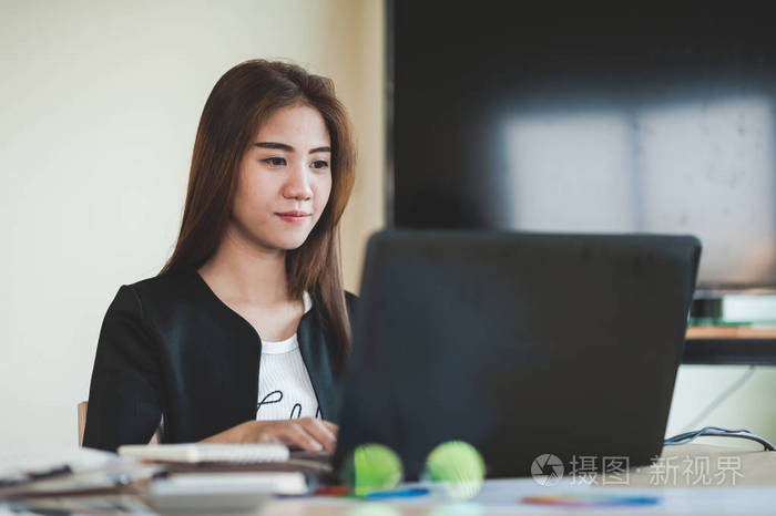 年轻的亚洲秘书女性在办公室使用笔记本电脑.工作日的商务人士生活方