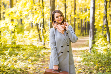 人, 时尚和自然概念美丽的年轻妇女站在秋季公园