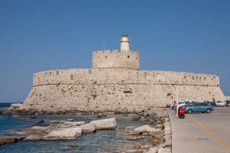 圣诞老人堡垒在码头在 Mandraki 港。在罗兹码头的防御堡垒。一座防御性的建筑物在一个港口在罗兹镇与灯塔