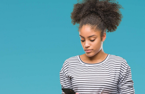 年轻的美国黑人妇女发短信使用智能手机在孤立的背景下, 一个自信的表情, 聪明的面孔认真思考