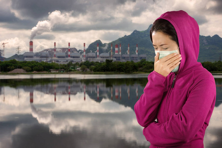 妇女打喷嚏, 妇女身着粉红色冬季服装戴面具面对空气污染背景