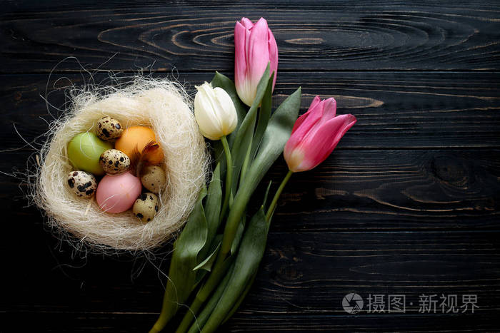 复活节彩蛋在巢与郁金香的组合。文本位置