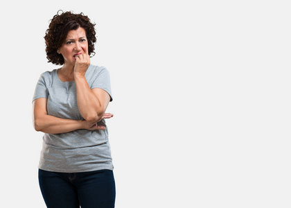 中年妇女咬指甲, 紧张, 很着急, 害怕未来, 感到恐慌和压力照片