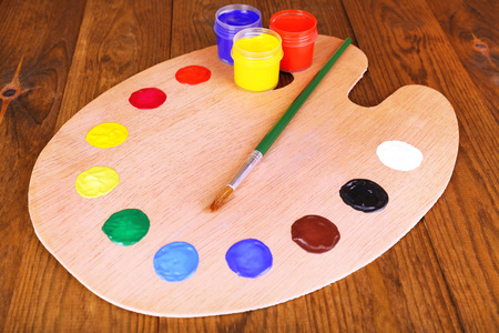 木制艺术调色板着颜料和画笔上表特写