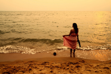 年轻的女子在日落海滩