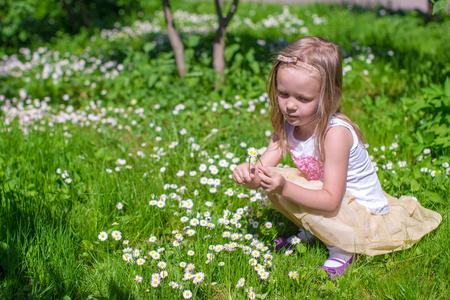 在绿色的林间空地摘花的小女孩