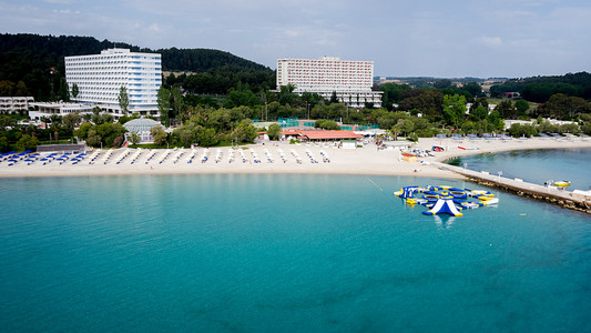 顶视图的海滩，游客 日光浴浴床和遮阳伞在芦墟