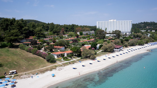 顶视图的海滩，游客 日光浴浴床和遮阳伞在芦墟