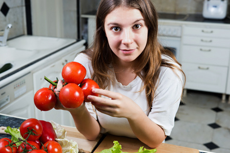 年轻女子捧着堆西红柿