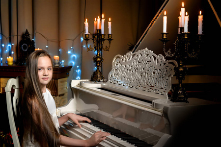 一个十几岁的女孩在圣诞夜用烛光弹奏钢琴