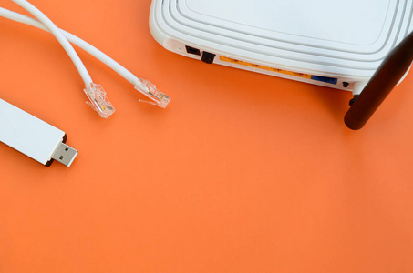 便携式 usb wi-fi 适配器和互联网电缆插头位于一个明亮的橙色背景