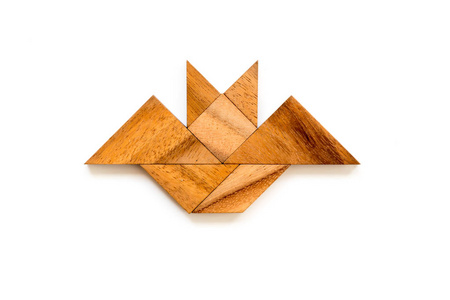 木蝙蝠白色背景的蝙蝠形状的木七巧板拼图照片