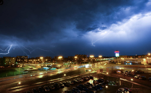 下雨的夜潮湿的路与灯在多云下雨夜与闪光照片