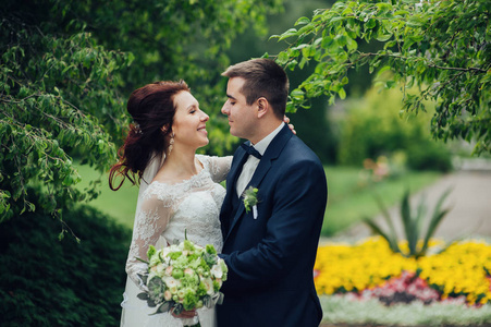 美丽的高加索婚礼情侣鲜花花束拥抱在公园