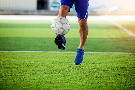 足球运动员在人造草坪上跳跃和射击球。足球运动员训练或足球比赛