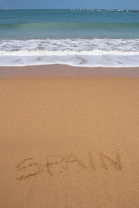 美丽的海滩与西班牙单词写在沙地上