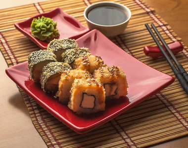 寿司卷套装在天妇罗在桌上配有芥末, 酱油, 日本料理