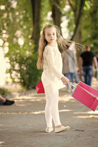 可爱的小女孩走在粉红色的购物袋