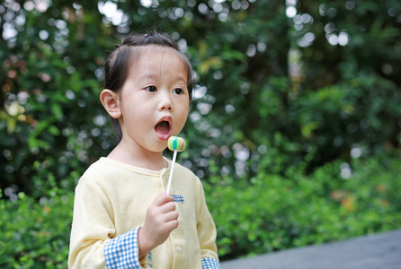 小女孩喜欢吃糖棒糖在公园里