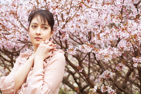 黑发女人在春天花朵的花园图片