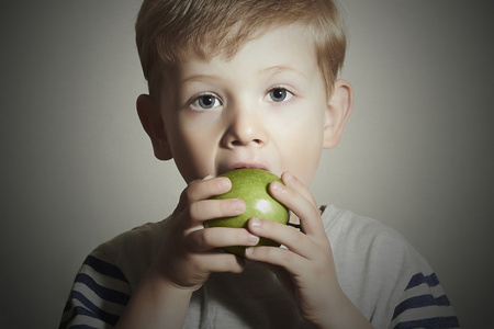 有趣的孩子饮食 apple.little 英俊男孩青苹果。健康食品。水果。享受餐