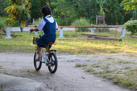 亚洲学生穿校服的女孩, 在 l 享受自行车