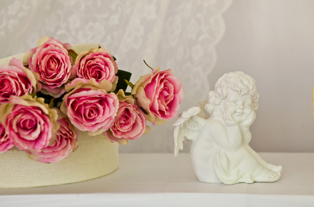 天使小雕像和芳香的玫瑰图片