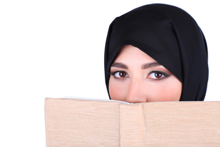 美丽的穆斯林阿拉伯语女人在灰色的背景上的书