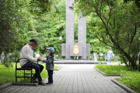 爷爷和她的孙子在春天公园散步。孙子