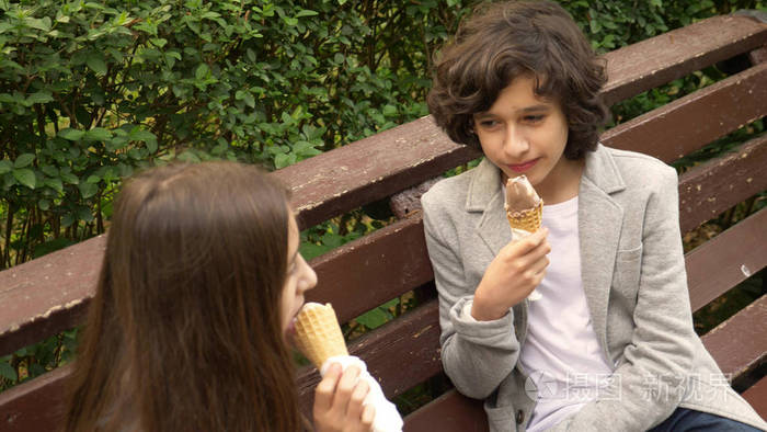可爱的青少年, 男孩和女孩吃冰淇淋在公园和谈话照片-正版商用图片06