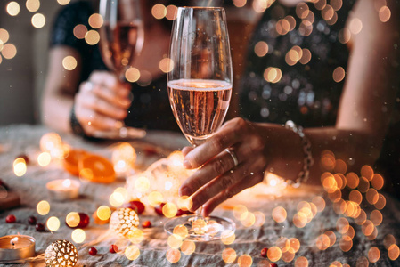 朋友庆祝圣诞节或新年前夕。玫瑰香槟派对桌
