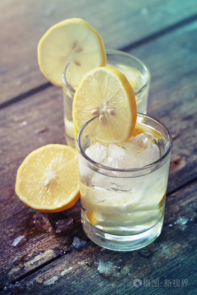 木质背景冰柠檬片柠檬水杯