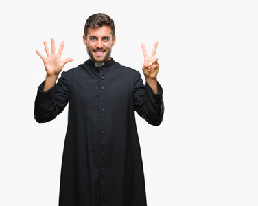 年轻的天主教基督教牧师男子在孤立的背景显示和指向七的手指, 而微笑着自信和快乐
