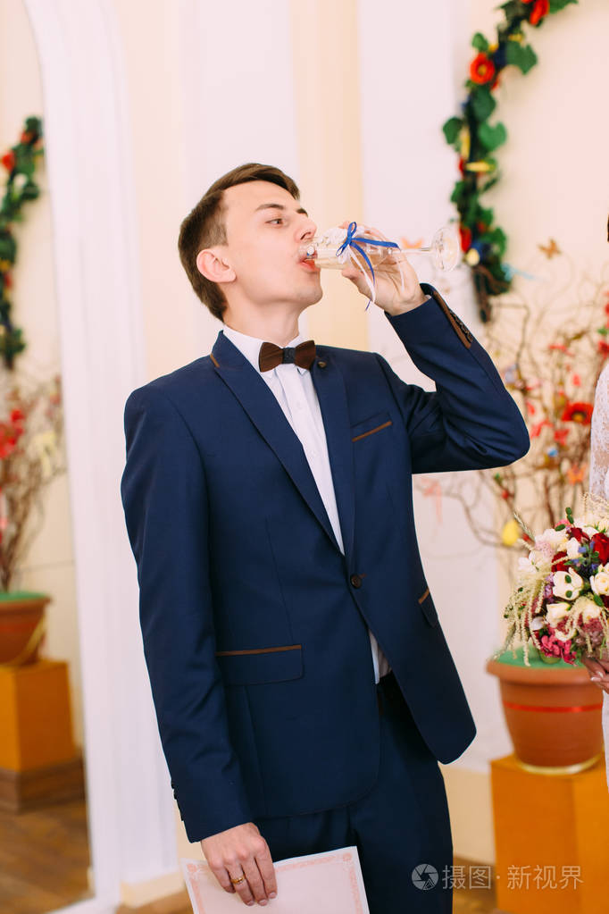 新郎喝香槟的半长照片