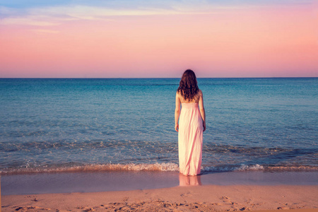 海边悬崖上一位长发披着长裙的美女画像年轻的黑发新娘在白色长裙摆在