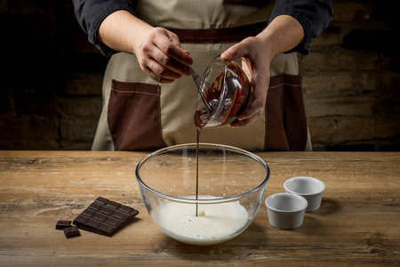 烘烤甜点巧克力与可可粉和面粉由厨师手。木背景