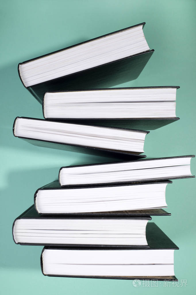 一堆书在绿色背景侧面视图