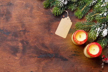 圣诞蜡烛和冷杉树枝覆盖在木质背景下的积雪。顶部查看圣诞背景与空间为您的问候